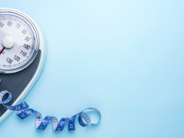A scale and a measuring tape are seen near the side of a blue background.