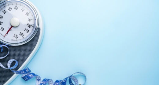 A scale and a measuring tape are seen near the side of a blue background.